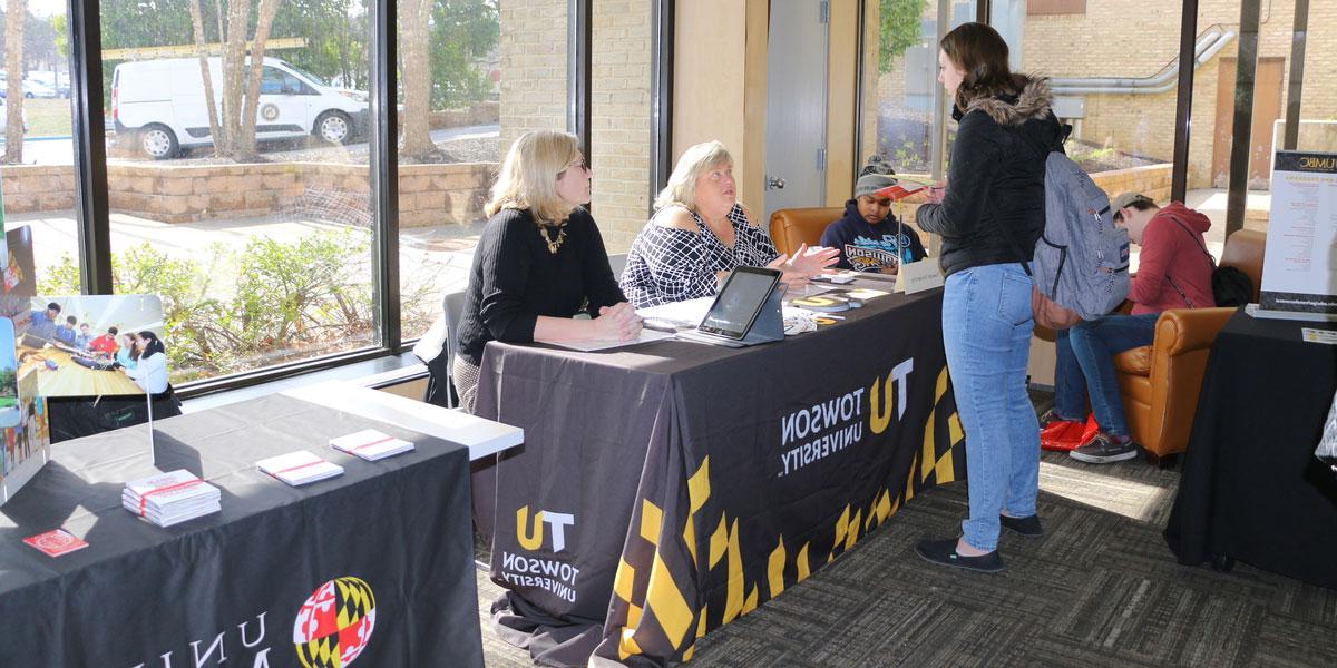 A student talking to representatives from Townson University.